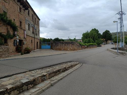 an empty street next to a brick building at Hotel Rural el Arrabal Siguenza in Sigüenza