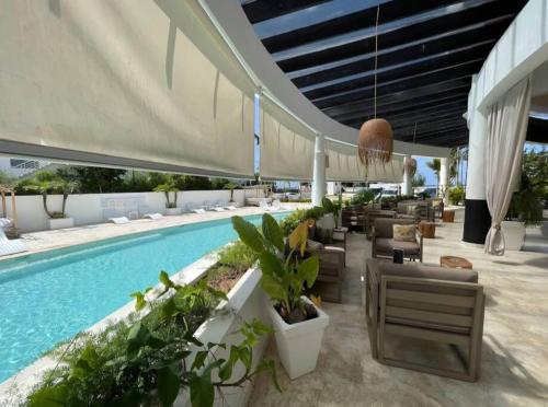 a resort with a swimming pool and lounge chairs and a pool at Amare Beach Front Condo in Las Terrenas