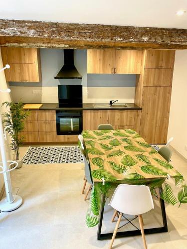 une cuisine et une salle à manger avec une table et des chaises dans l'établissement Gite de la Palme, à Lapalme