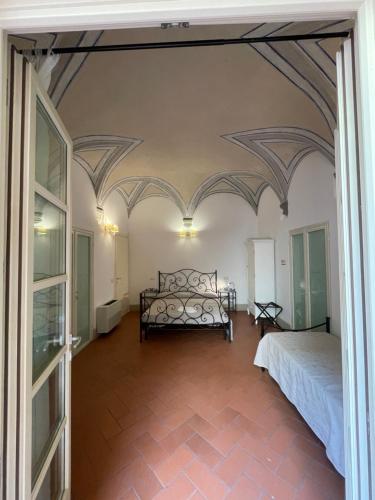 a bedroom with a bed in a room with ceilings at BonConvento Guesthouse - HiTuscany in Pisa
