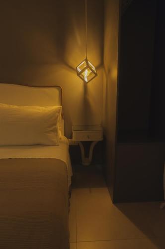 a bedroom with a bed and a light on the wall at B&B Sbarco dei 1000 Marsala in Marsala