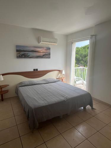 une chambre avec un lit et une grande fenêtre dans l'établissement Les villas Maristella, Villa Melu, à Aregno