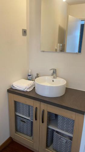 une vanité de salle de bain avec un lavabo et un miroir dans l'établissement A6 Familiale Parking Wifi 1 Grd Chambre 3 lits 1 canap 2 à 6 personnes AMELIE, à Imphy