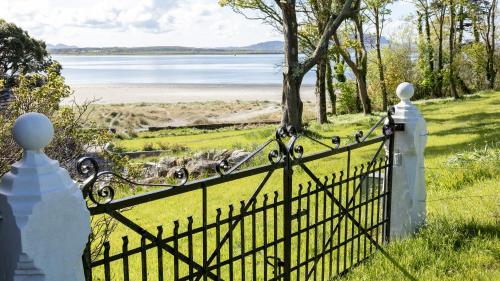 an iron gate with a view of a body of water at Lissadell on The Beach in Lissadell