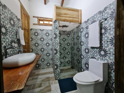 a bathroom with a toilet and a sink at La Mercedes Cattaleya Hostal BY MH in Yumbo