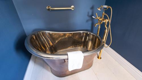 a metal tub in a bathroom with a blue wall at Lissadell on The Beach in Lissadell