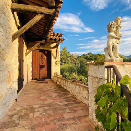 a stone walkway leading to a building with a statue at Villa Azur Star, Vence, French Riviera in Vence