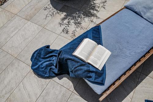 Un libro sobre una manta azul. en Villa Viamo, en Cesarica