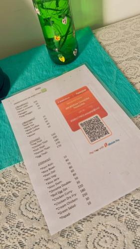 a menu on a table with a vase at Windchime9 in Guwahati