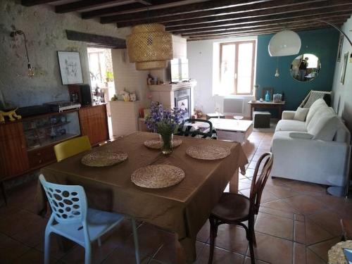 une cuisine et un salon avec une table et des chaises dans l'établissement Adorable maison tourangelle proche Amboise, à Souvigny-de-Touraine