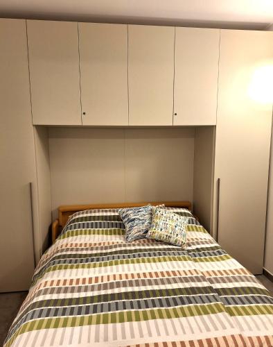 a bedroom with a bed with white cabinets and two pillows at Dolce Far Niente in Alassio