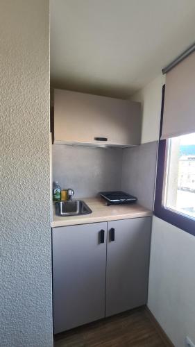a small white kitchen with a sink and a window at Kamus in Baden-Baden