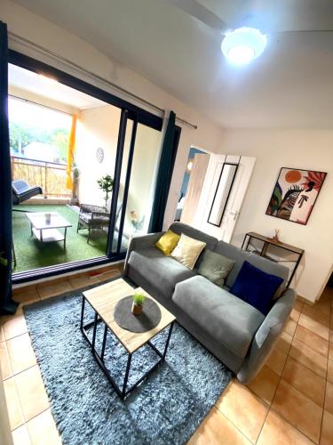 a living room with a couch and a table at Charmant T2 - Moufia Sainte-Clotilde vue Mer & Montagne in Saint-Denis