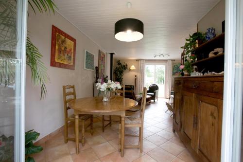 une salle à manger avec une table et des chaises en bois dans l'établissement Proche de Bordeaux et Saint Emilion, maison au calme avec grand jardin, à Salleboeuf