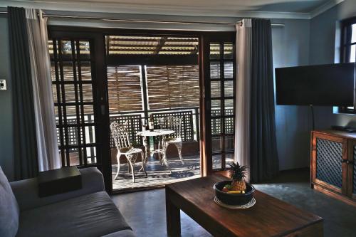 a living room with a couch and a table and a window at Villa La Mercy Chalet No load shedding or water outages in La Mercy