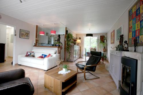 un salon avec un canapé blanc et une table dans l'établissement Proche de Bordeaux et Saint Emilion, maison au calme avec grand jardin, à Salleboeuf