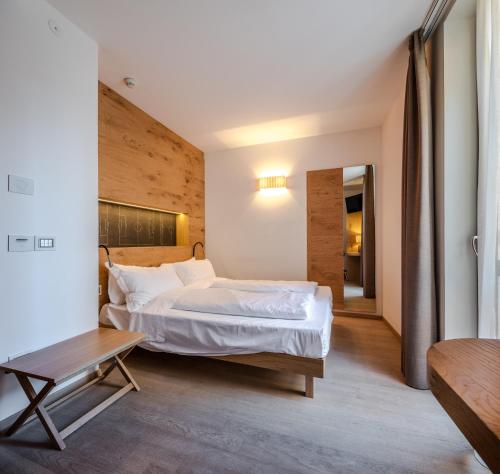 a bedroom with a large bed and a table at Albergo Caffe Centrale in Mezzocorona