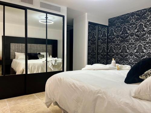 une chambre avec un grand lit blanc et un miroir dans l'établissement Au rythme des cigales, à Laouque