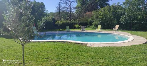 une petite piscine dans une cour avec deux chaises de jardin dans l'établissement La Villa des Fleurs, à Saint-Simon-de-Bordes