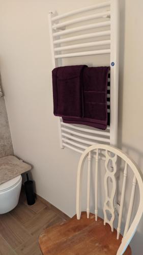 a white chair in a bathroom with towels at Svečių namelis KNYGŲ NAMAS in Kelmė