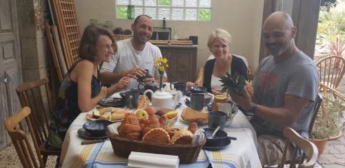 a group of people sitting around a table with food at les forges du lou in Jugon Les Lacs