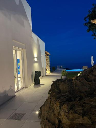 a white building with a view of the ocean at night at Villa Jarito in SantʼAgata sui Due Golfi
