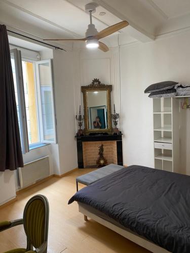 une chambre avec un lit, un miroir et une chaise dans l'établissement Appartement 2 pièces haussmannien, à Narbonne