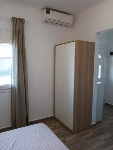 a bedroom with a white cabinet and a bed at The Garden Studio 2 in Kriopigi