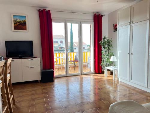 - un salon avec des rideaux rouges et une télévision dans l'établissement Le Provence 28m2 Lecques Parking-400m Plage Mer, à Saint-Cyr-sur-Mer