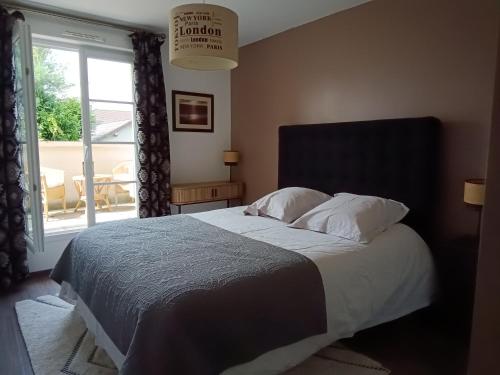 a bedroom with a large bed with a window at 2 chambres d'hôtes in Wissous