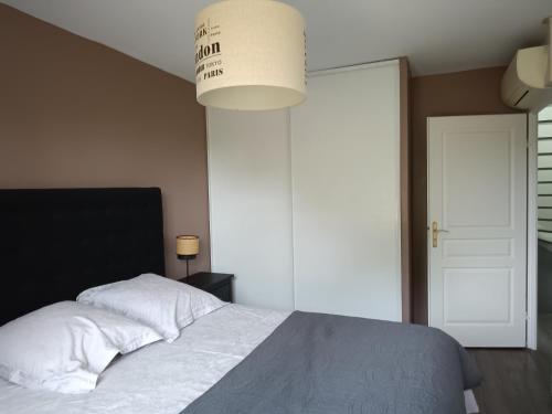 a bedroom with a bed and a large light fixture at 2 chambres d'hôtes in Wissous