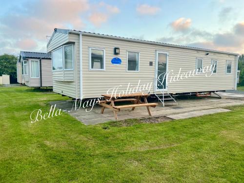 a mobile home with a bench in front of it at Bella-Mays Holiday Hideaway in Lincolnshire