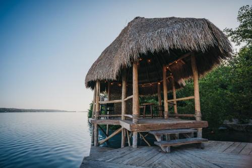 a hut on a dock on the water at Kokoro Mio Hotel & Wellnes in Xul-Ha
