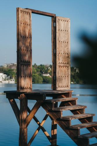 a wooden chair sitting on top of the water at Kokoro Mio Hotel & Wellnes in Xul-Ha