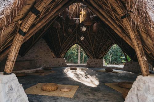 a room with a straw roof with baskets on the floor at Kokoro Mio Hotel & Wellnes in Xul-Ha