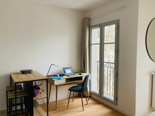 une pièce avec un bureau avec un ordinateur portable et une fenêtre dans l'établissement Studio terrasse Villa Aubert Vincennes, à Vincennes