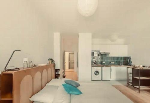 un salon avec un lit et une cuisine dans l'établissement Studio terrasse Villa Aubert Vincennes, à Vincennes