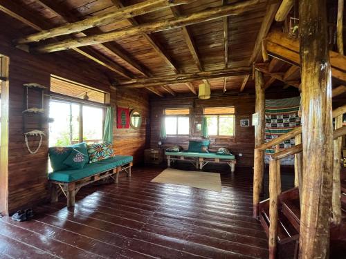 a living room with green furniture in a log cabin at Queen Elizabeth Gorge Cottages in Rubirizi