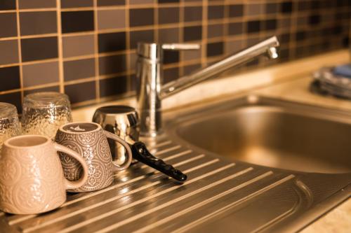two coffee mugs sitting on a counter next to a sink at Vila Zhiti in Durrës