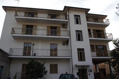 an apartment building with balconies and a car parked in front at Comfort in riva al mare in Belmonte Calabro