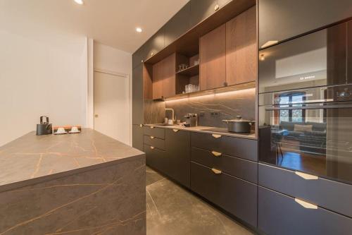 une cuisine avec des armoires marron et un comptoir dans l'établissement Astoria Haussmannien - Appartement de caractère, à Aix-les-Bains