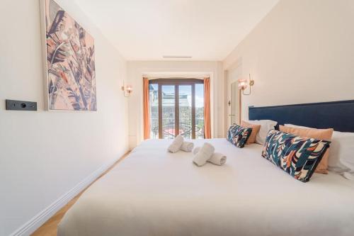 un grand lit blanc avec deux oreillers dessus dans l'établissement Astoria Haussmannien - Appartement de caractère, à Aix-les-Bains