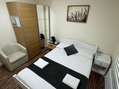 a bedroom with a bed and a chair in it at Namaste Palace Hotel in Norwich