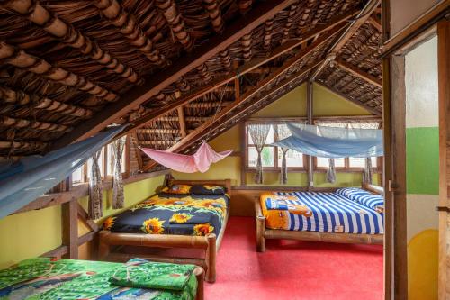 a bedroom with two beds and a hammock at La Casa Mompiche in Mompiche