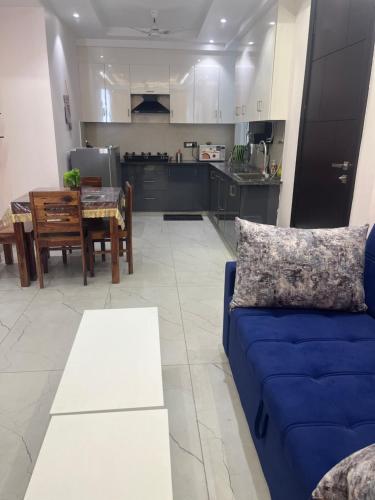 ein Wohnzimmer mit einem blauen Sofa und einer Küche in der Unterkunft Luxury Home 2BHK 2Bathrooms Kitchen Nr Laxman Jhulla in Rishikesh