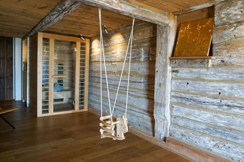 a room with a wooden wall with a swing at 5Sterne Ferienwohnung im Fachwerk mit Bergblick in Alleinlage und großem Garten, Infrarotkabine in Humberg