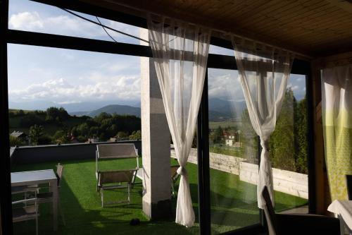 a window with curtains and a view of a yard at Apartmán NAVRCHU in Brezno