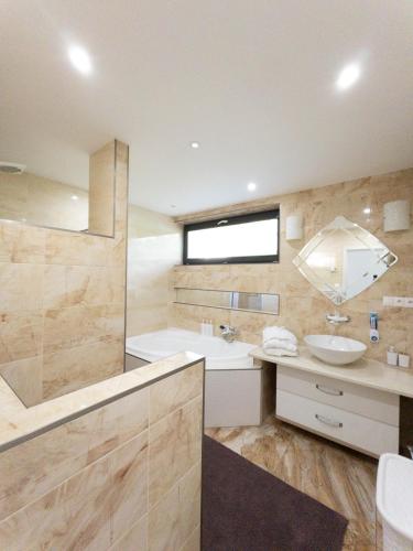 a large bathroom with a sink and a tub at Apartmán NAVRCHU in Brezno