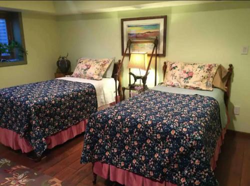 a bedroom with two beds and a painting on the wall at Trail Boss King EnSuite-Prairie Rose B&B - 1200 sq ft Suite in Cheyenne