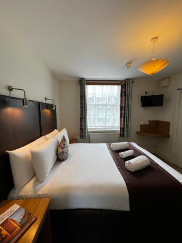 a bedroom with a large bed with two towels on it at Castle Limes Hotel in Warwick